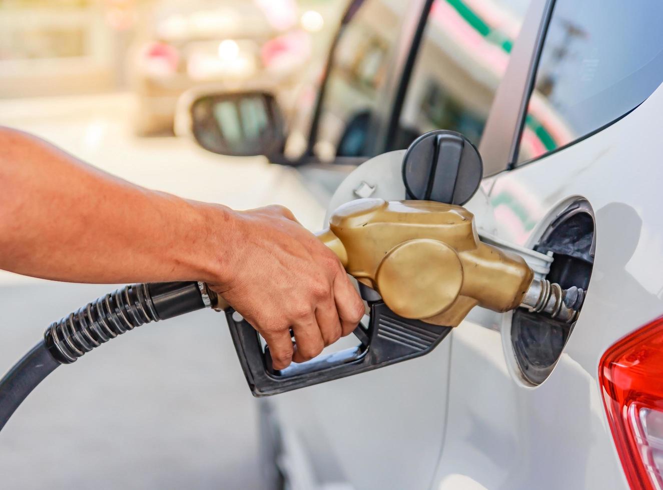 mano che riempie la macchina di carburante foto