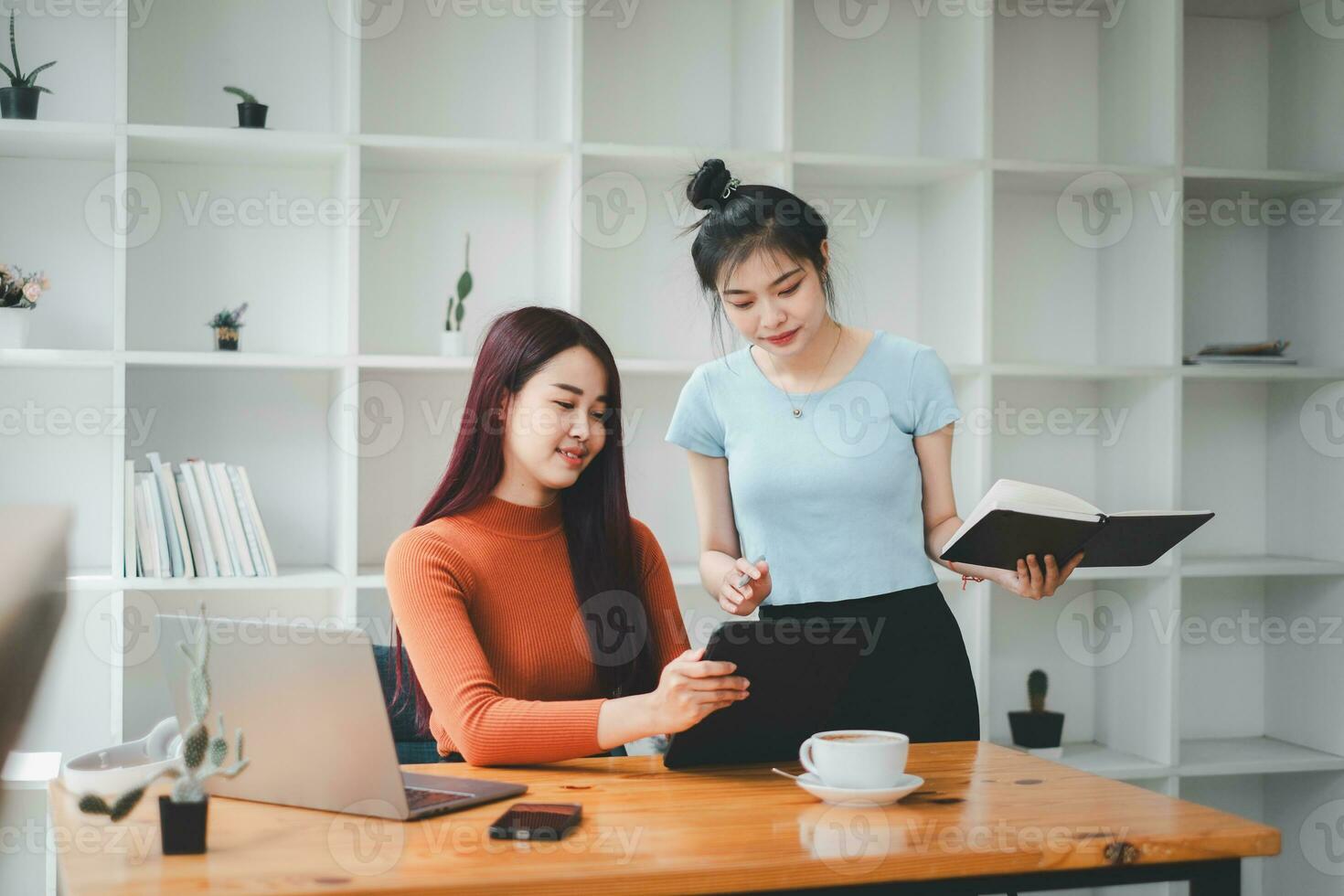 attività commerciale donna parlando per sua collega durante un' incontro nel un' sala riunioni, attività commerciale squadra Lavorando su digitale tavoletta. foto