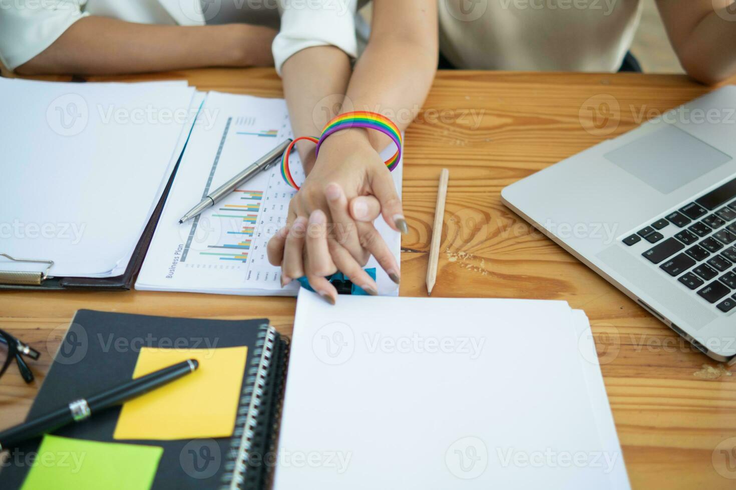 lgbt q coppia indossato arcobaleno braccialetti simboleggiante lgbt q gruppo e tenuto mani per mostrare amore, amicizia e gentilezza. e lgbt q coppia anche promesso per amore ogni altro per sempre. copia spazio per testo foto