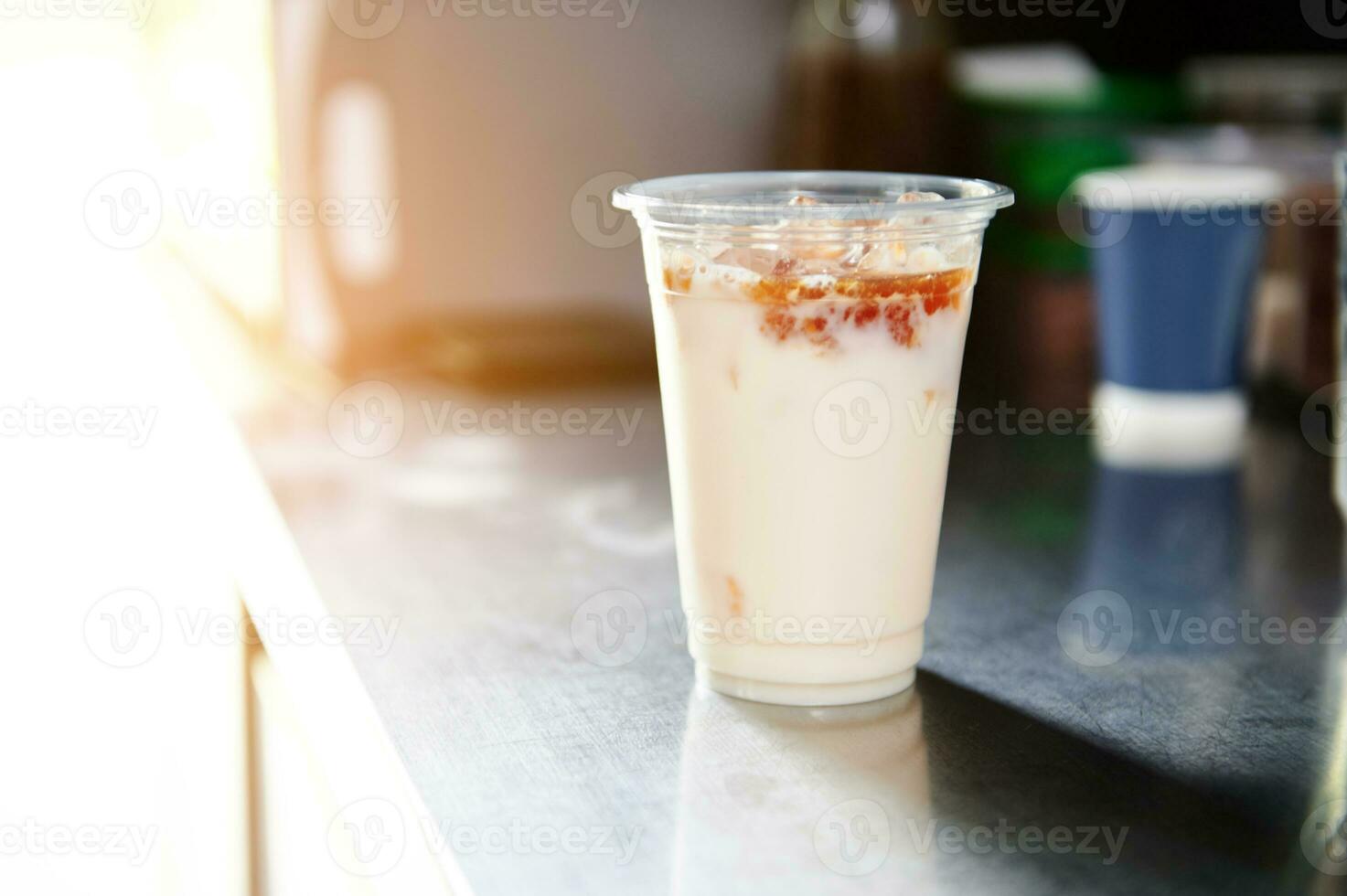 ghiaccio caffè con caramello salsa nel un' porta via tazza su un' bar contatore foto