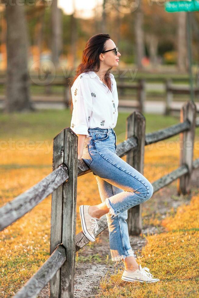 ritratto di contento giovane donna all'aperto nel il parco a tramonto foto