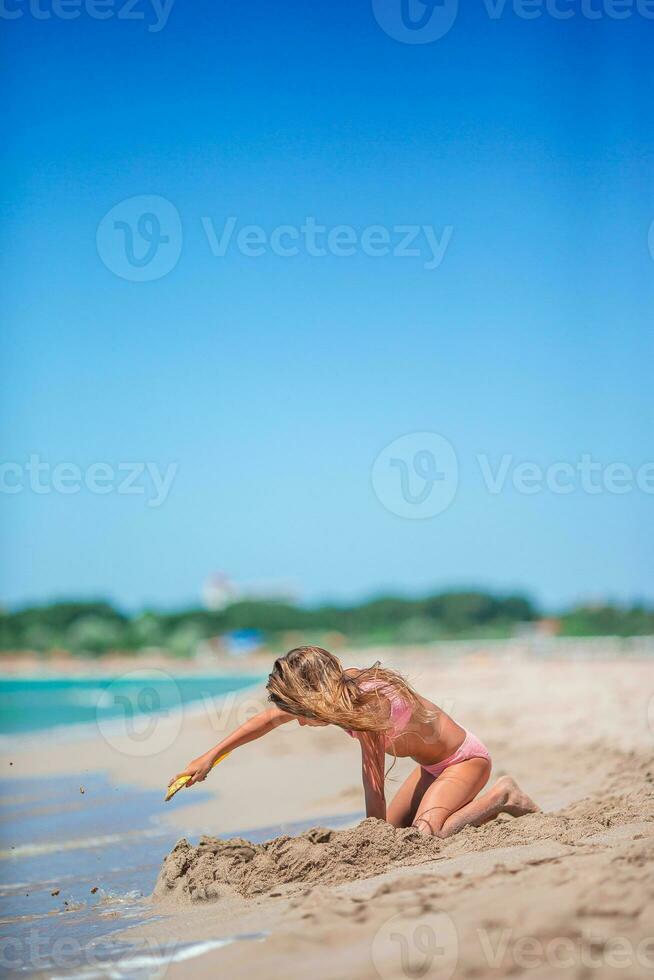 adorabile bambina che gioca con i giocattoli da spiaggia durante le vacanze tropicali foto