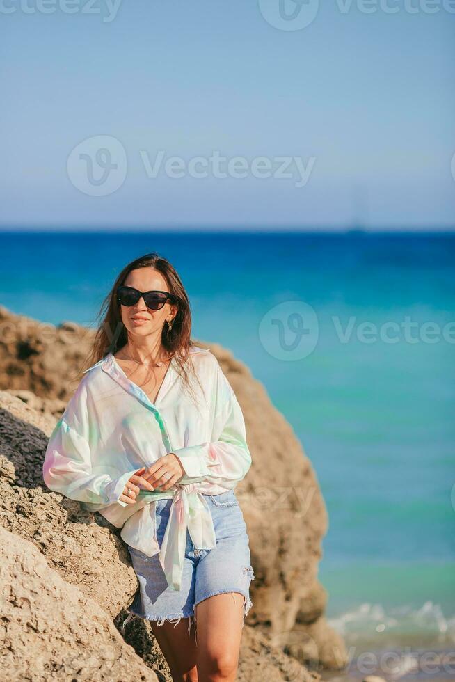 giovane contento donna su il spiaggia godere sua estate vacanza. ragazza è contento e calma nel sua restare su il spiaggia foto