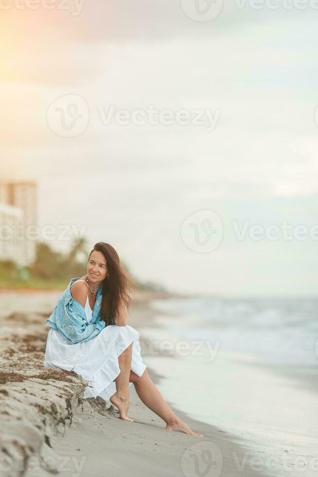 contento donna godendo bellissimo tramonto su il spiaggia foto