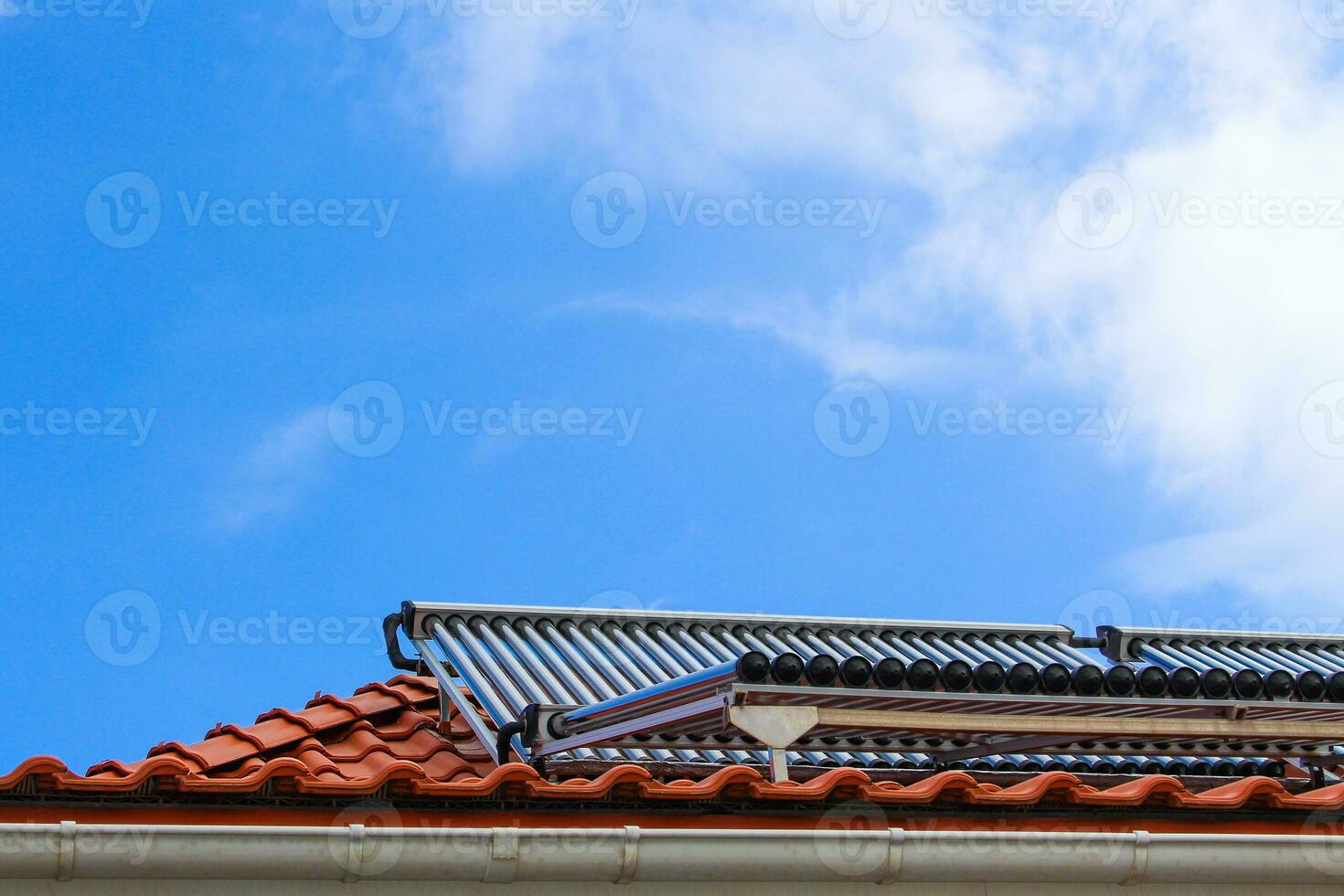 solare collezionisti per caldo acqua e riscaldamento su il tetto di Casa su blu cielo sfondo foto