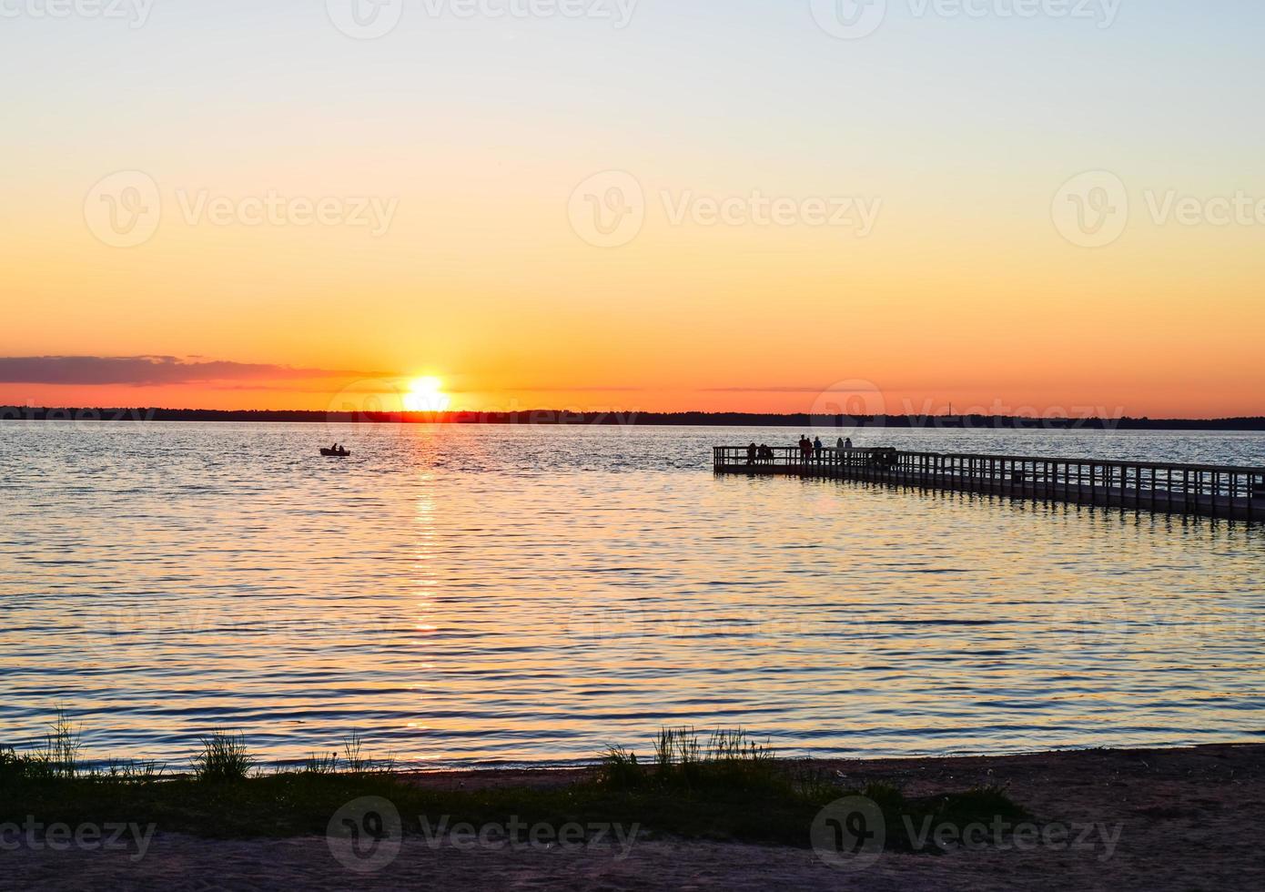 lago rekyva con molo e persone che guardano il tramonto. viaggio turistico in siauliai, lituania. foto