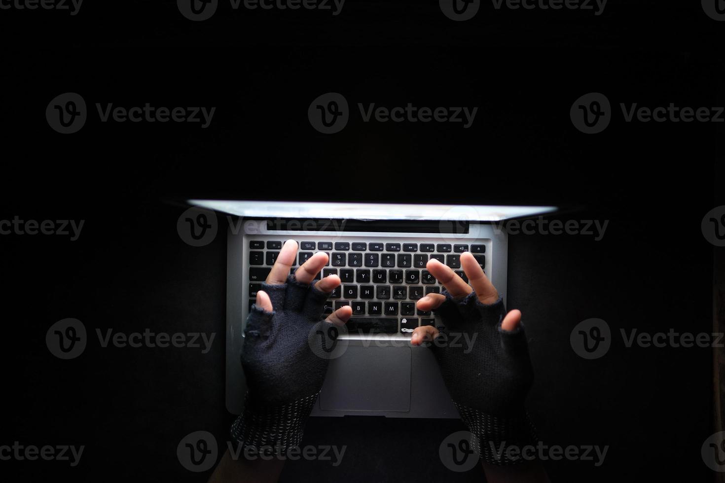 mano di hacker che ruba dati dal laptop dall'alto verso il basso foto