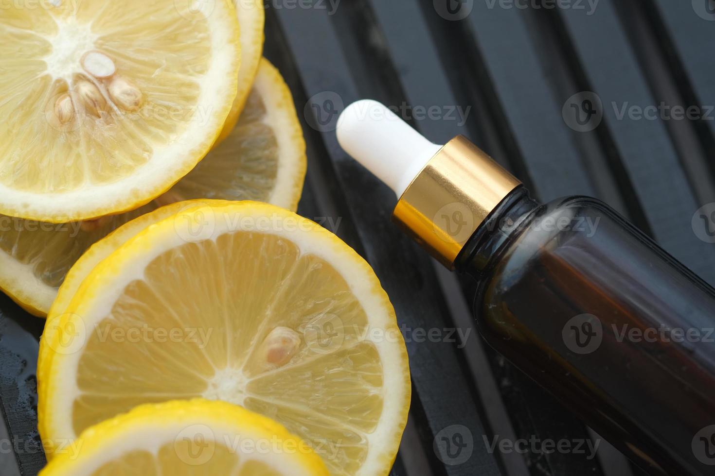 contenitore di vetro di olio e limone sul tavolo foto