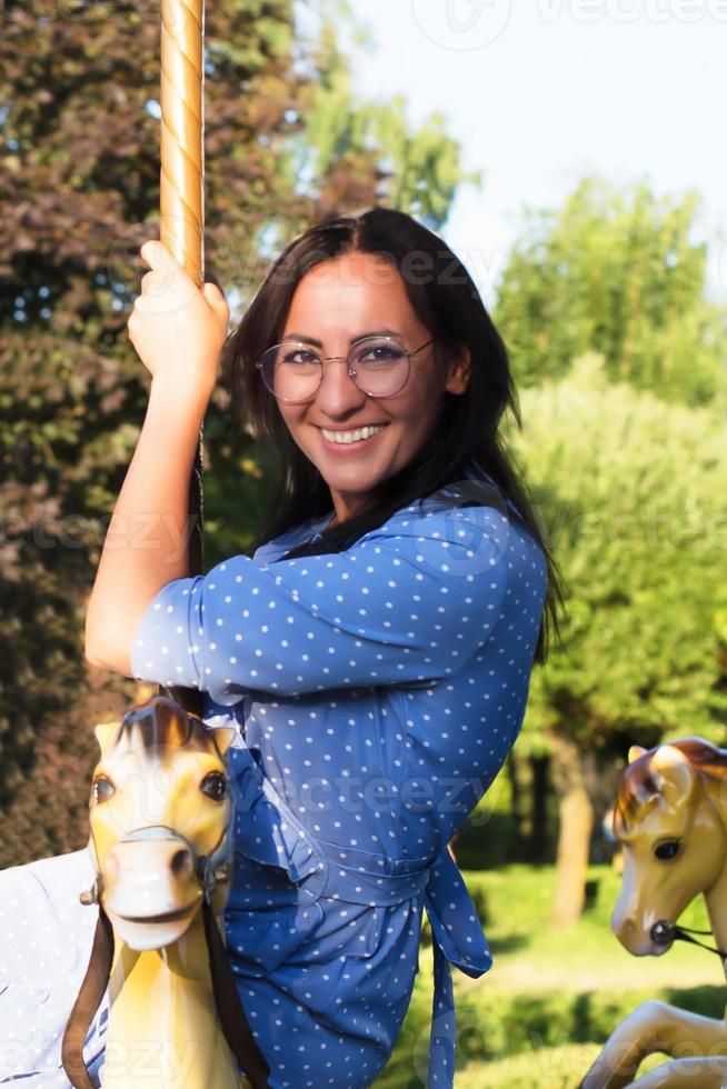 ragazza felice nel parco su una giostra, in estate foto