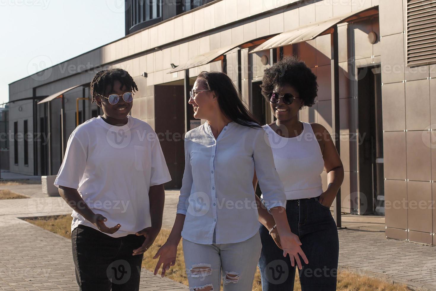 ragazze felici di diverse nazionalità stanno camminando per strada foto