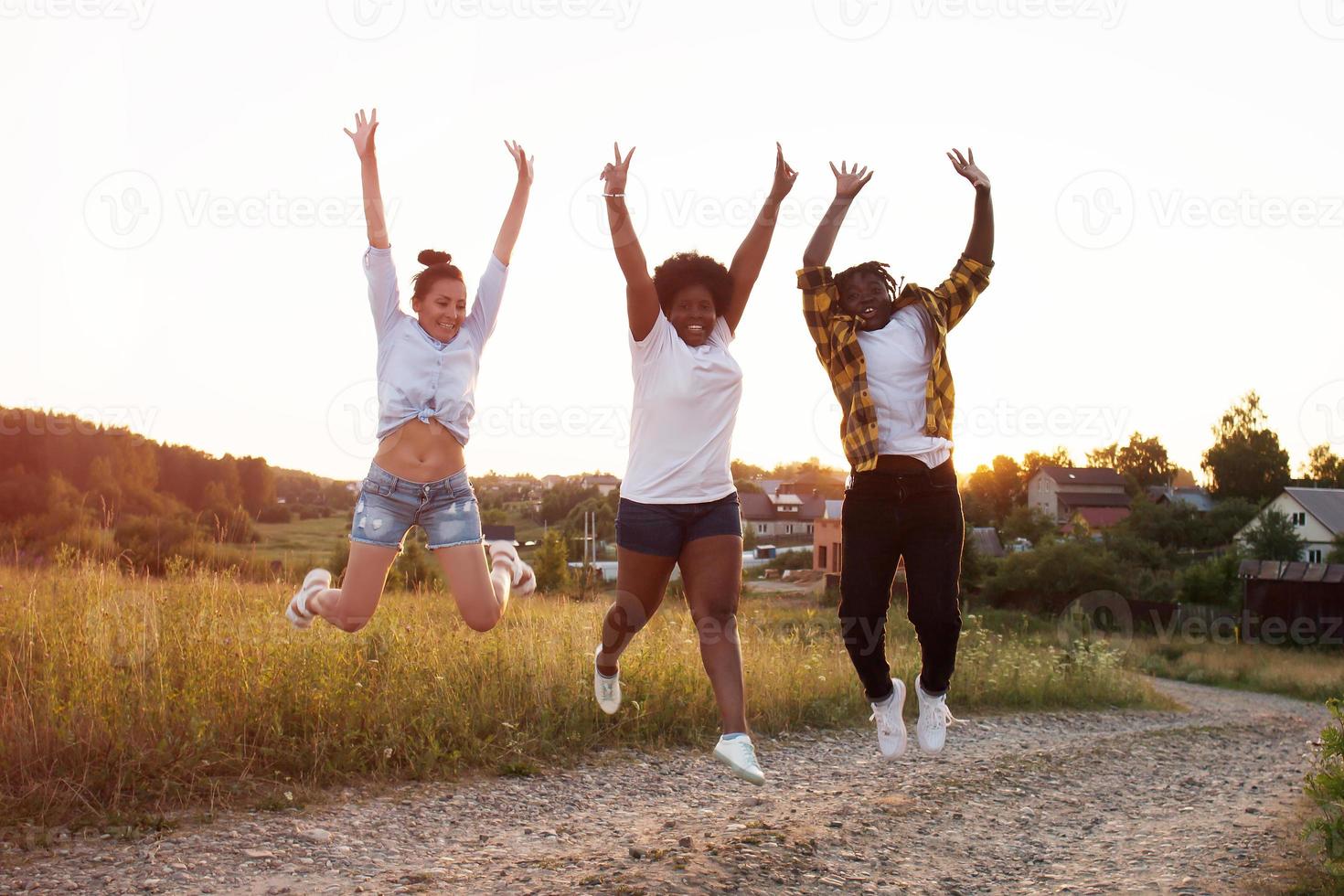 ragazze felici di diverse nazionalità saltano e si divertono foto