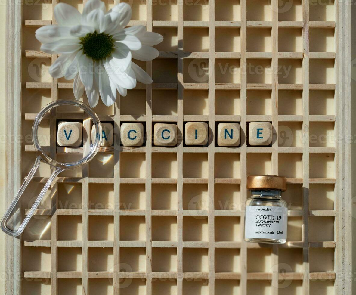 vaccino e un' fiore su un' di legno tavola foto