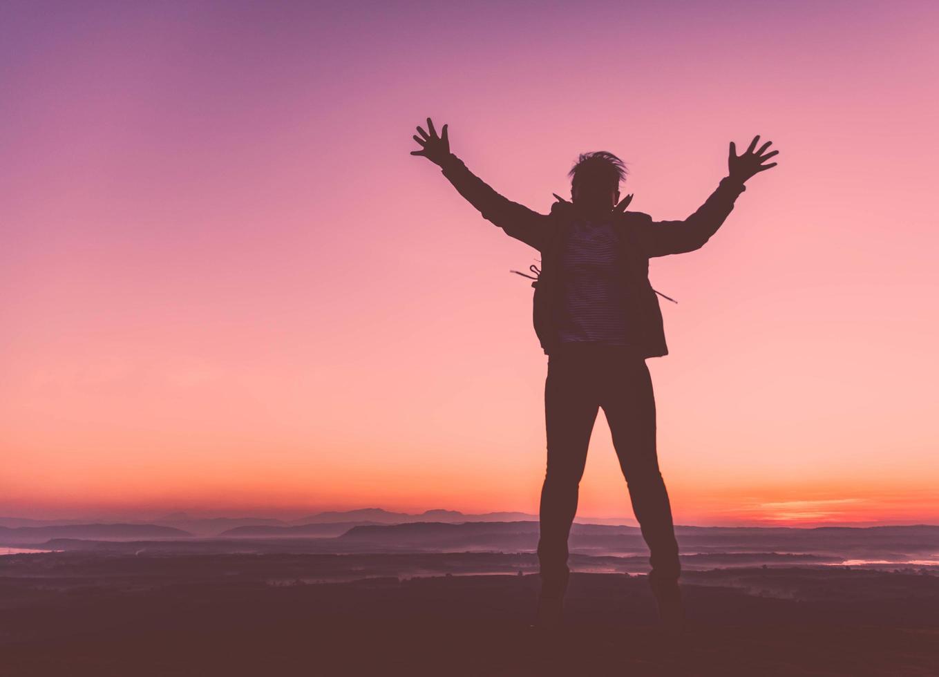 silhouette di una ragazza felice che salta sullo sfondo del tramonto sunset foto