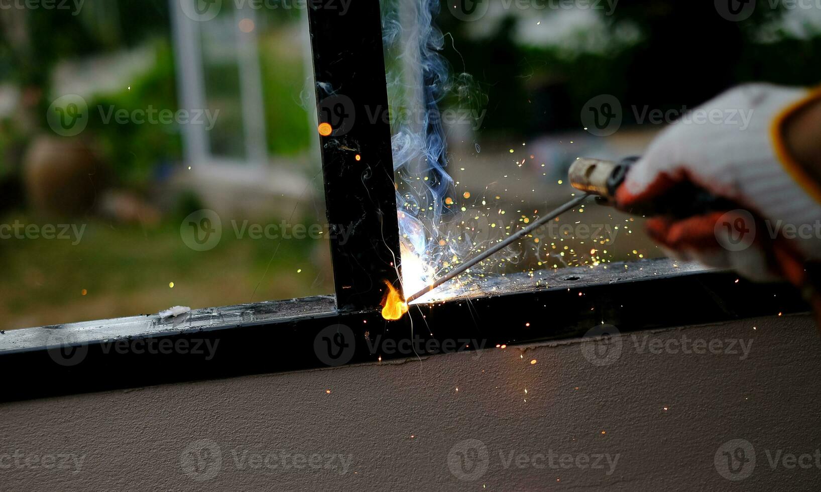 il tecnico saldatore sta saldando l'acciaio con scintille foto