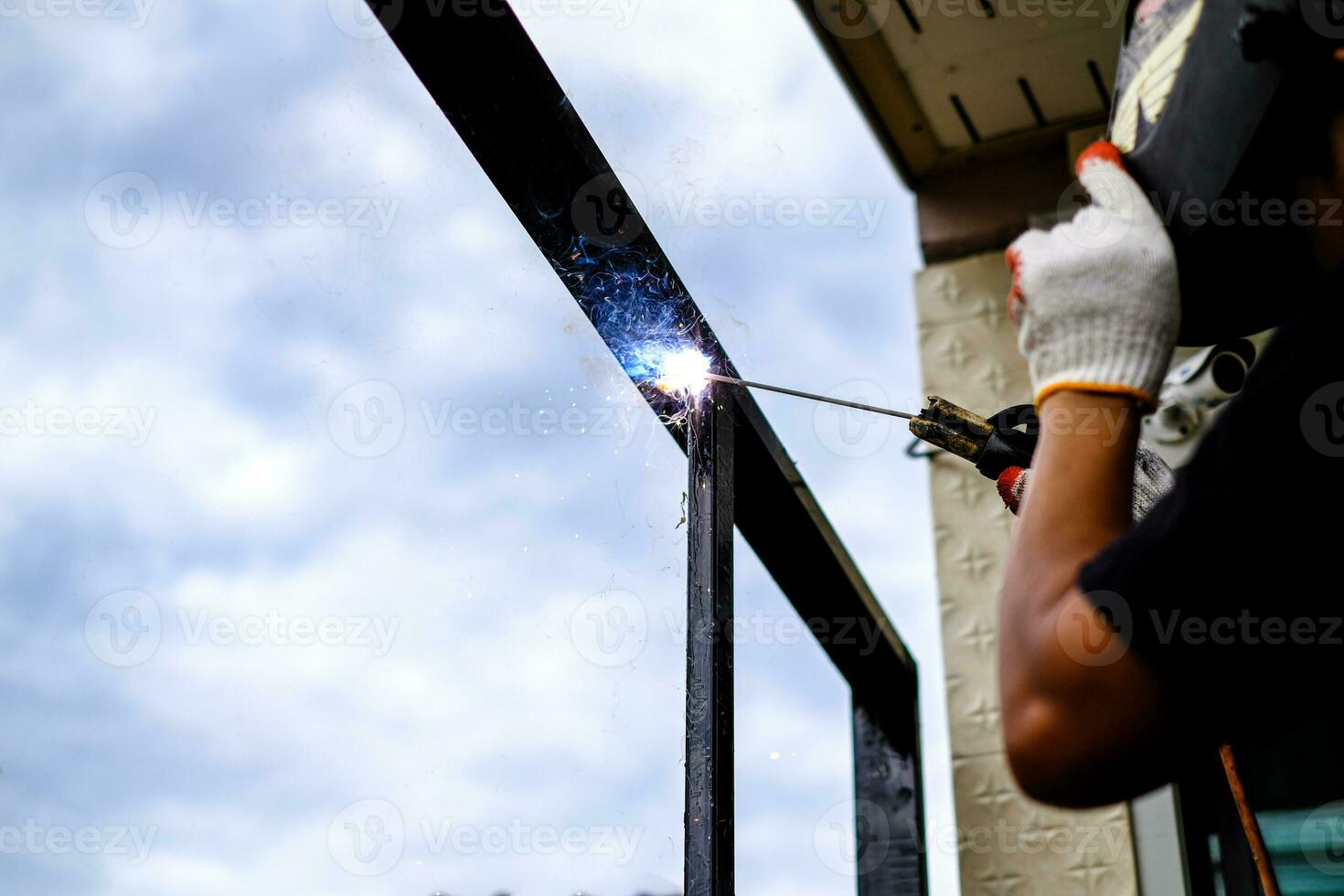 il tecnico saldatore sta saldando l'acciaio con scintille foto