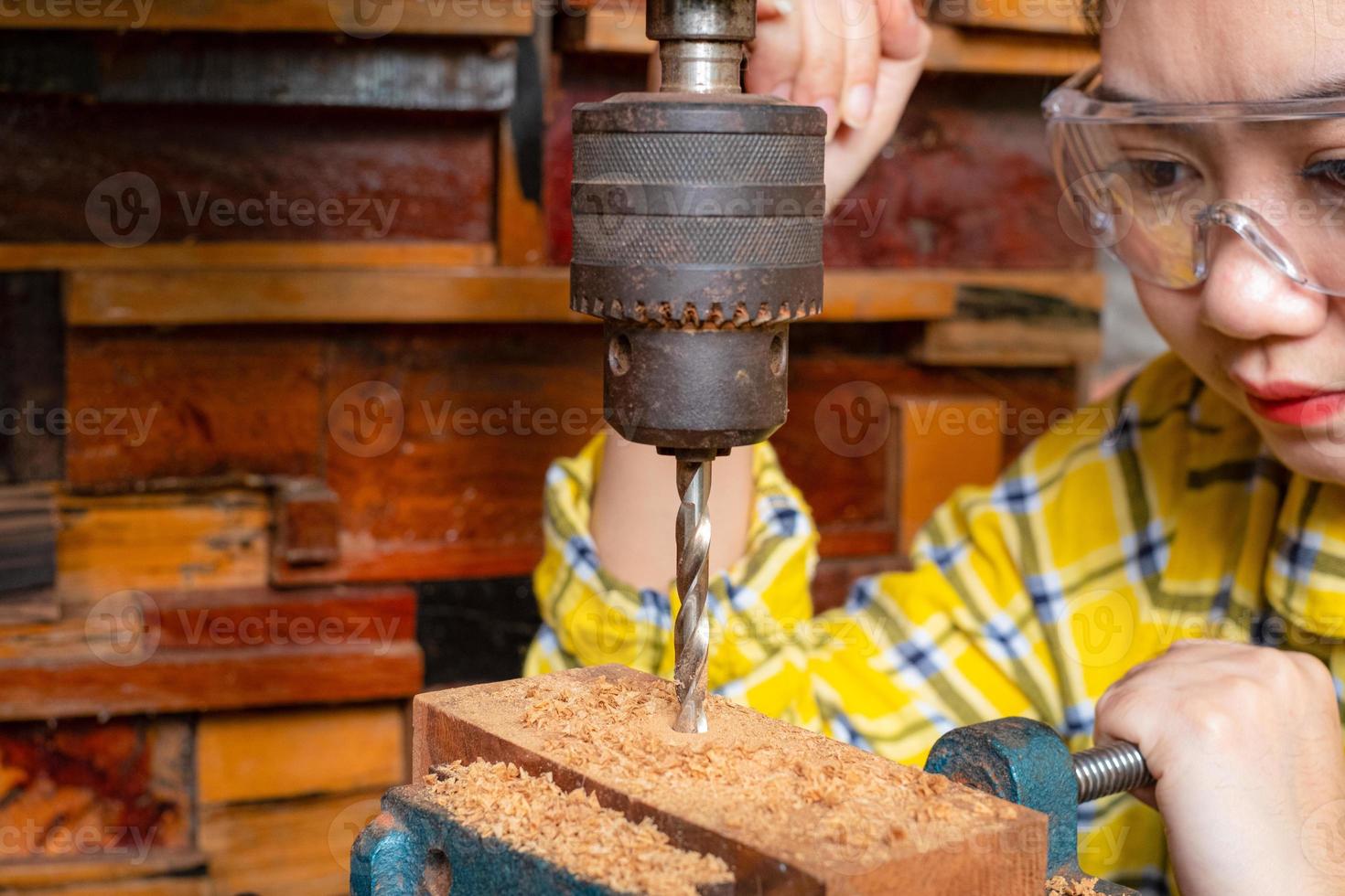 le donne in piedi sono lavori artigianali trapanare il legno foto