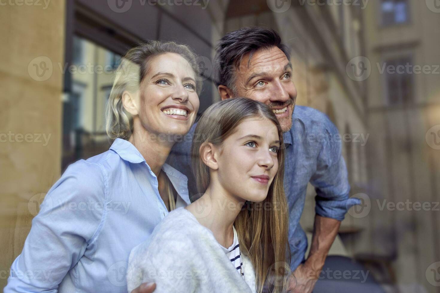 ritratto di contento famiglia dietro a vetro di finestra foto