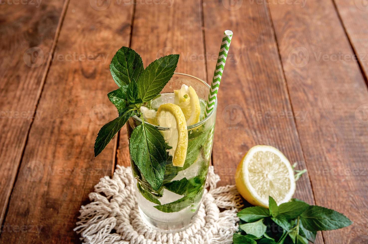 limonata fredda con limone su un tavolo di legno marrone foto