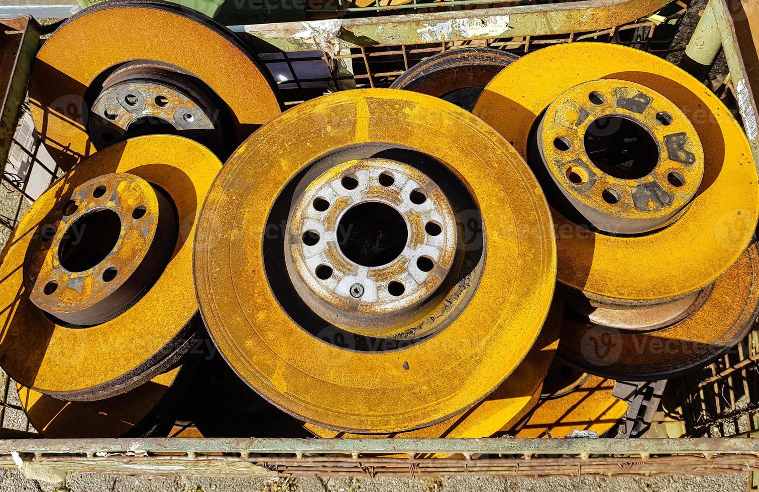 vecchi dischi dei freni per auto arrugginiti nella discarica foto