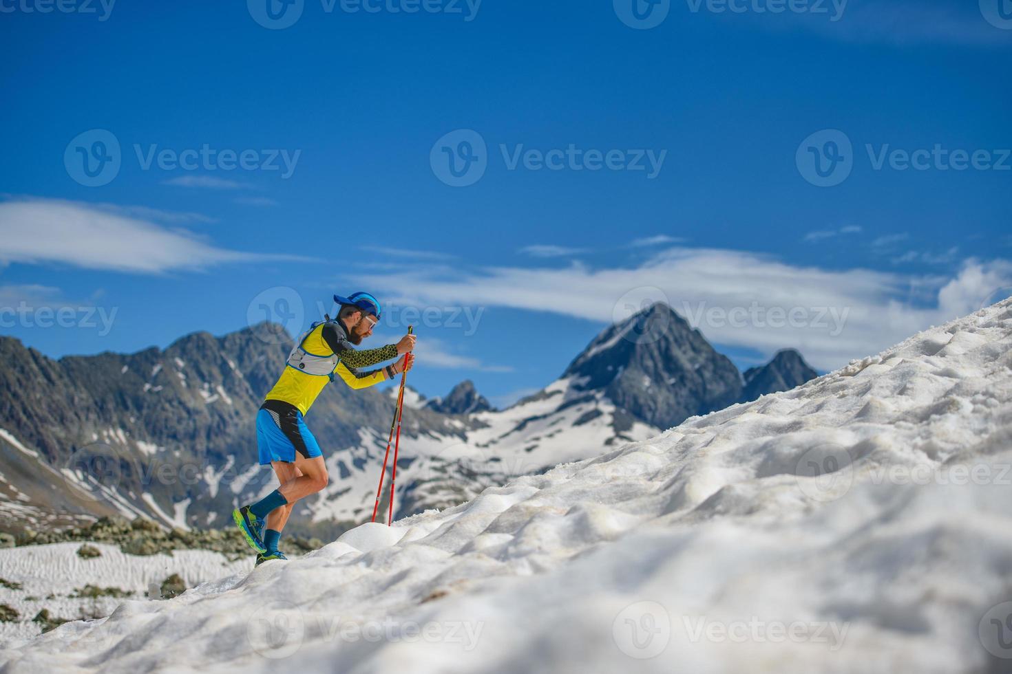 allenamento di skyrunning con i bastoncini sulla neve in salita foto
