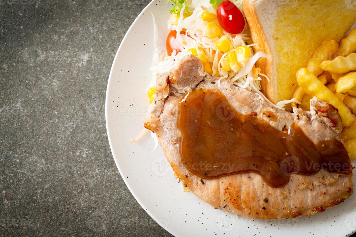 bistecca di maiale con salsa di peperoni neri e mini insalata foto