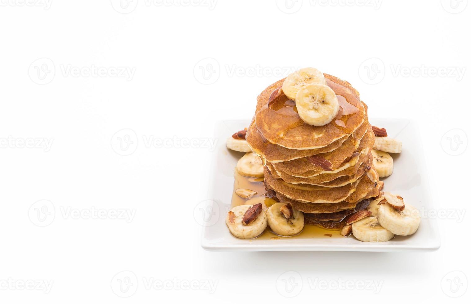 pancake alla banana alle mandorle con miele su sfondo bianco foto