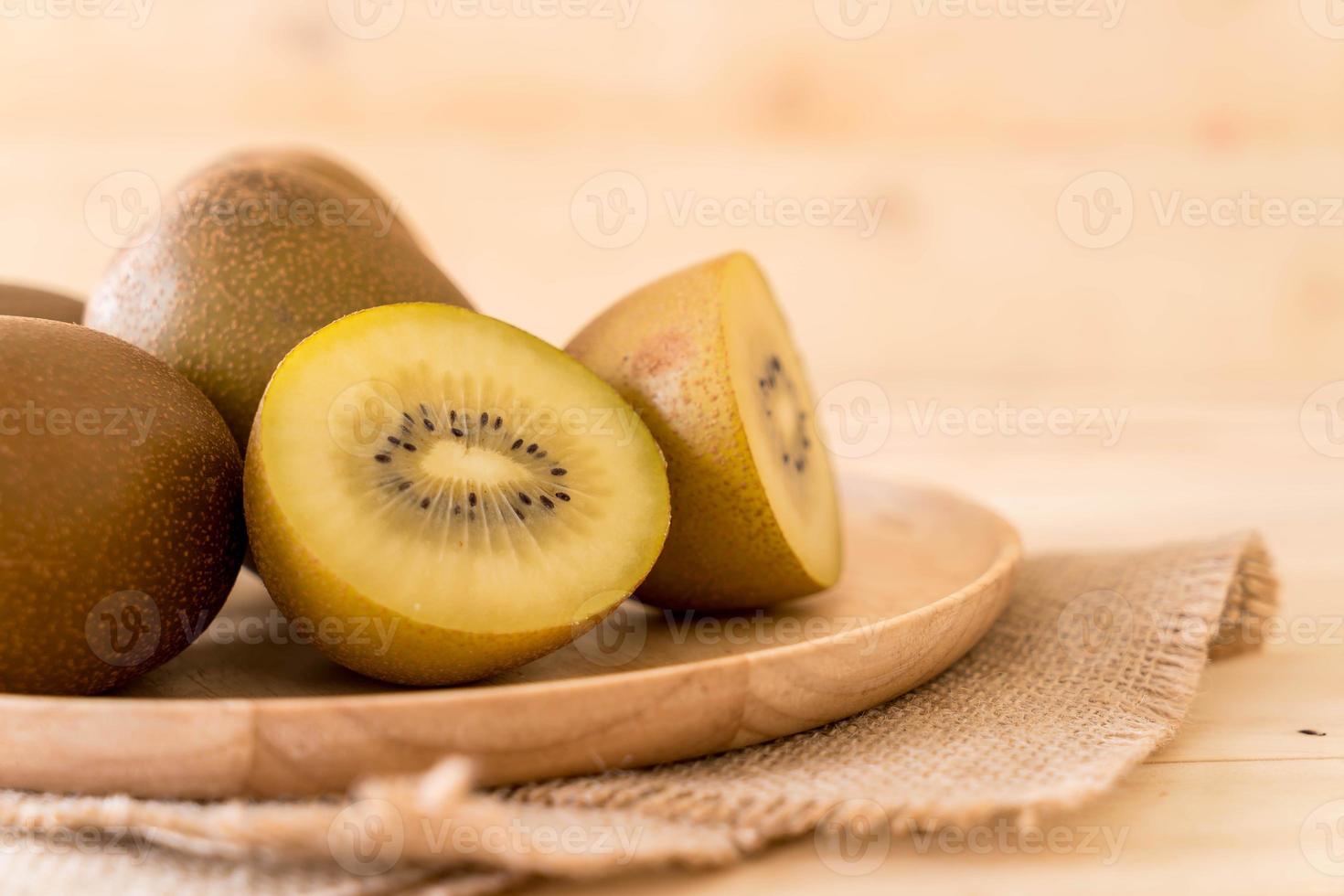 kiwi dorato fresco nel piatto di legno foto