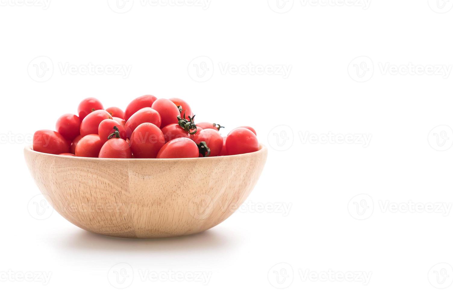 pomodori freschi in ciotola di legno su sfondo bianco foto