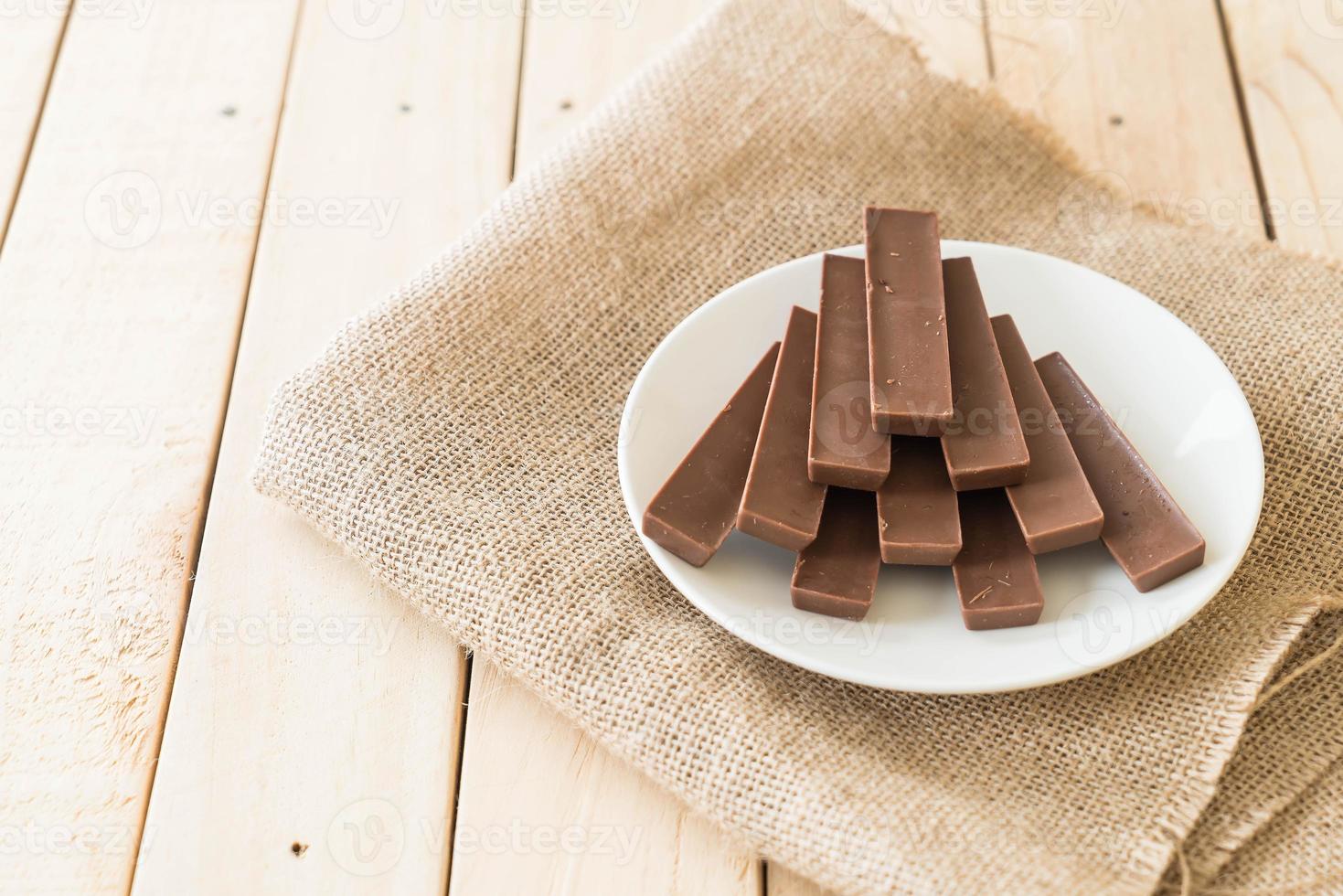 barrette di cioccolato su fondo in legno foto