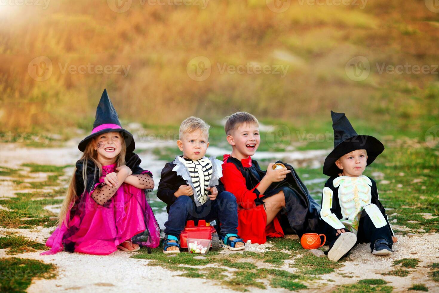 giovane bambini trucco o trattamento durante Halloween . bambini siamo seduta su il strada nel Halloween costumi. foto