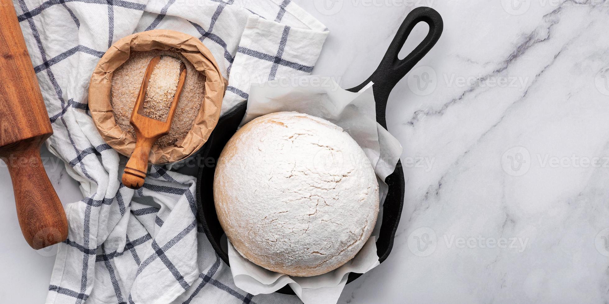 pasta di lievito fatta in casa cruda fresca che riposa in una padella di ghisa foto