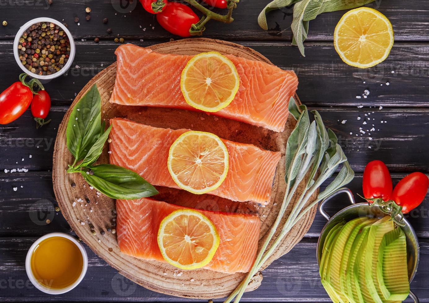 filetto di salmone crudo tagliato a pezzi, pepe sale aneto limone rosmarino foto