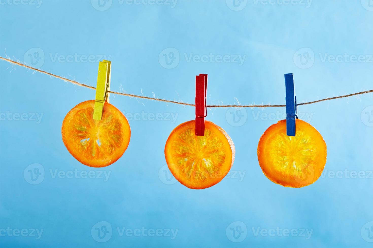 fette di arance essiccate o mandarini sono appese su stendibiancheria foto