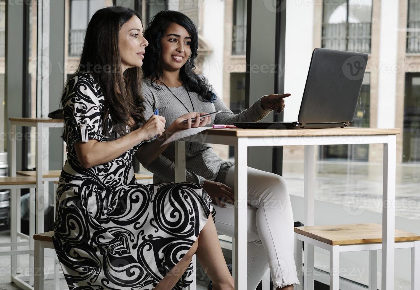 donne d'affari che lavorano con il laptop sul posto di lavoro foto