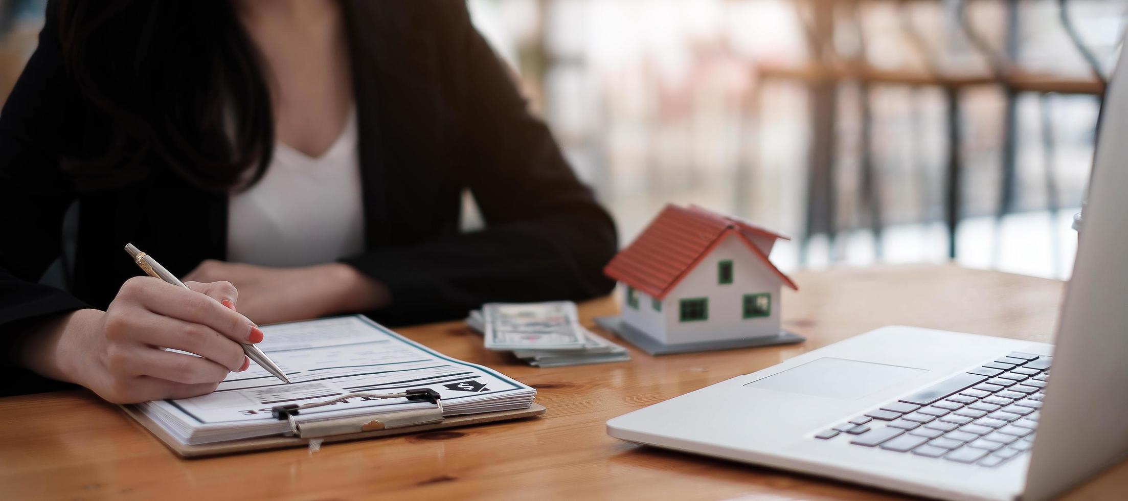 vista ravvicinata mani di una donna d'affari che firma una casa in leasing foto