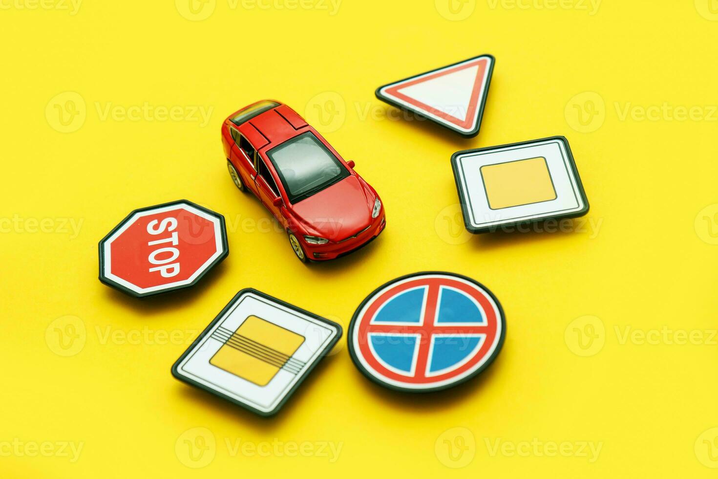 giocattolo strada segni e un' rosso auto su un' giallo sfondo foto