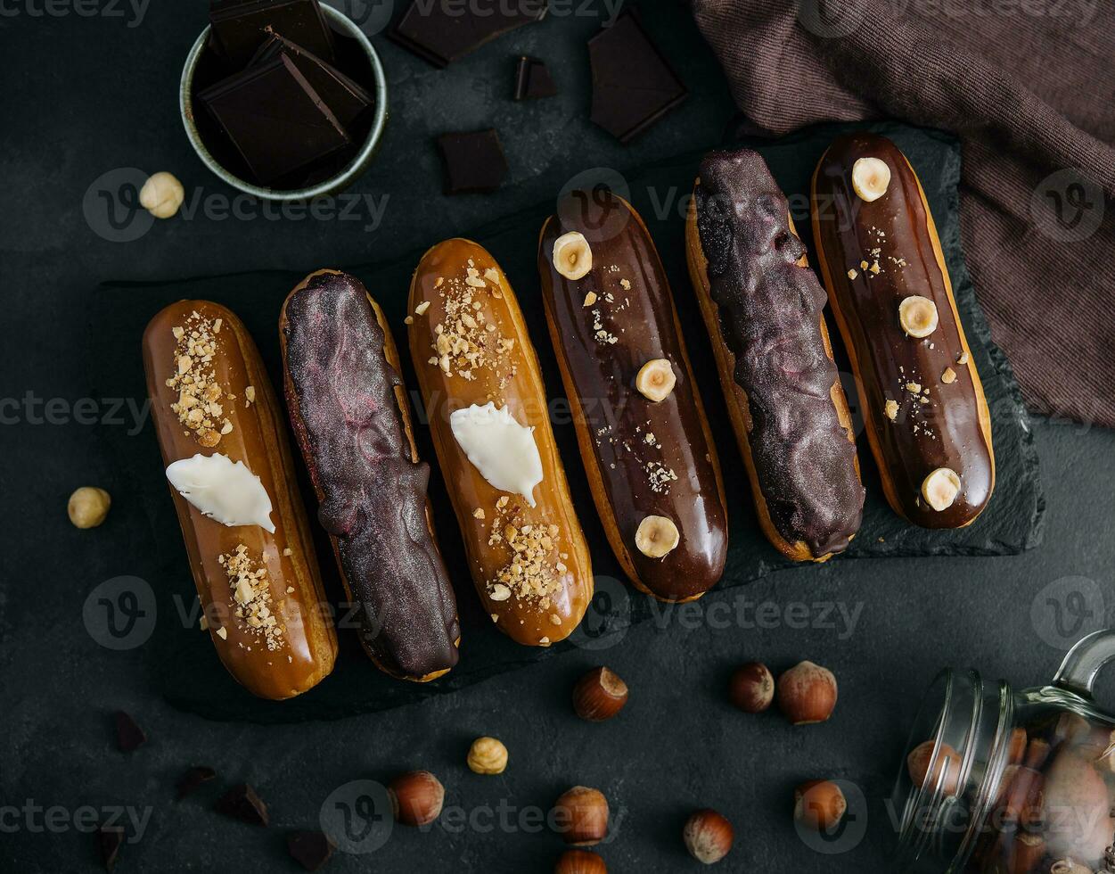 dolce cioccolato eclairs su nero di legno tavola foto