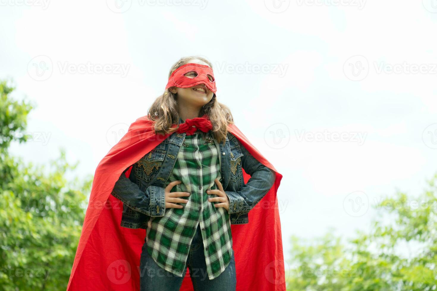 su un' bellissimo giorno nel il parco, un' giovane ragazza gode sua vacanza. giocoso con un' rosso supereroe costume e maschera. foto