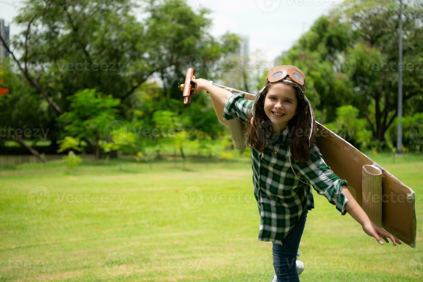 un' poco ragazza su vacanza a il parco con un' pilota attrezzatura e volante attrezzatura. correre in giro e avere divertimento con sua sogni. foto