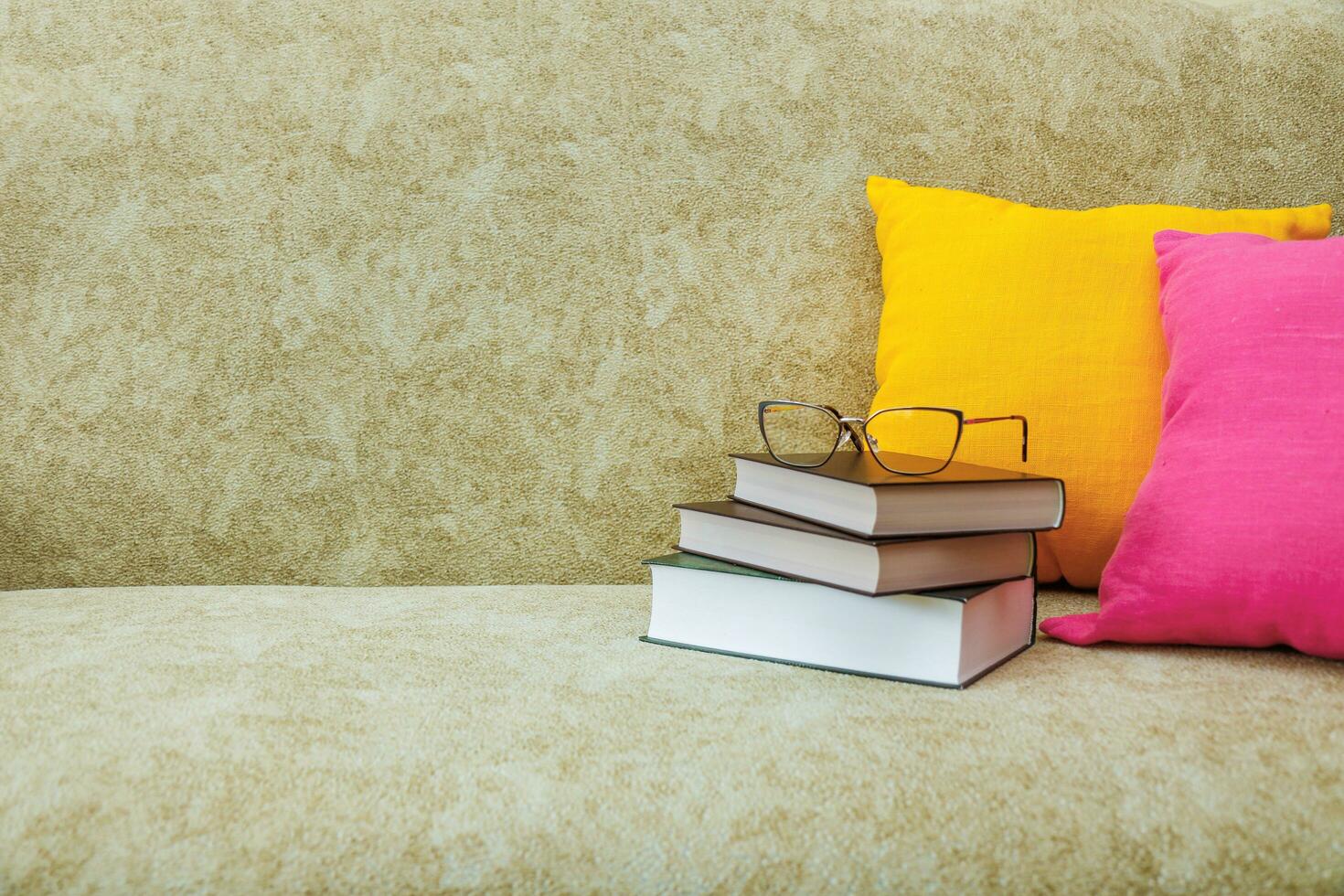 libri con bicchieri su un' divano con colorato cuscini con copia spazio foto