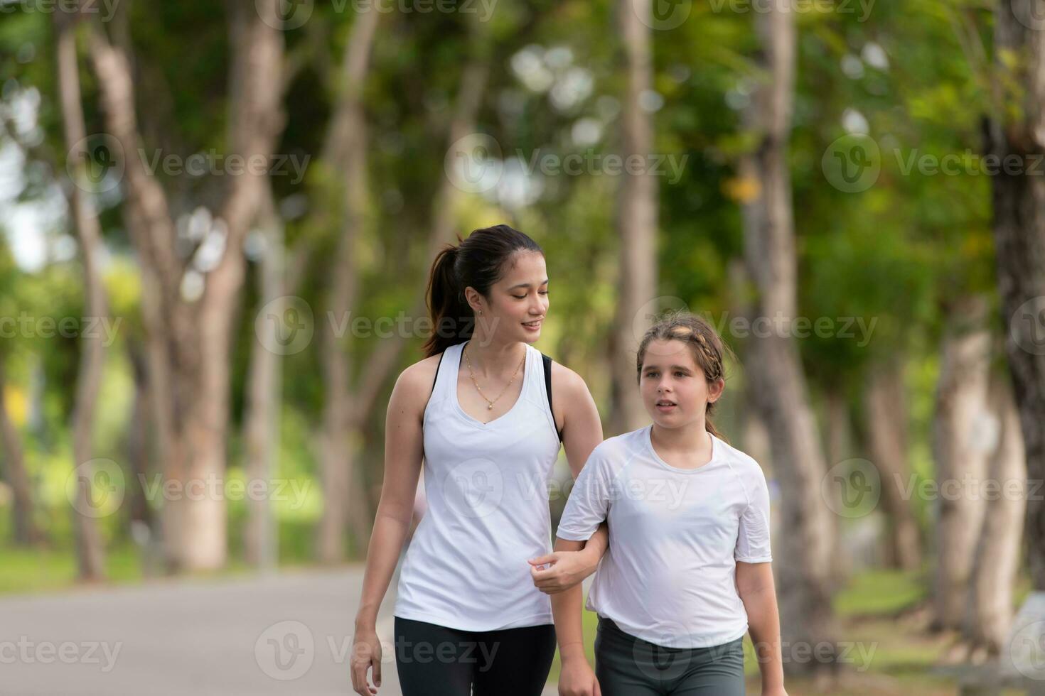 giovane femmina e poco ragazza con a piedi esercizi nel il città parco foto