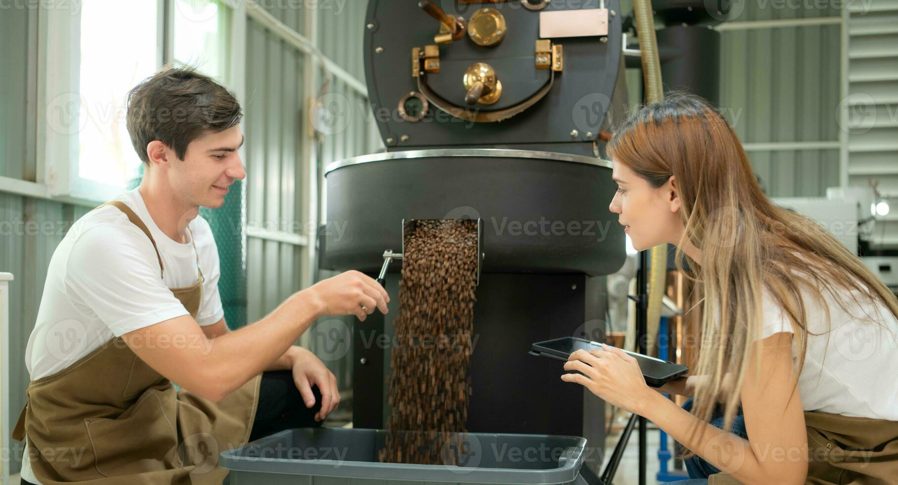 giovane uomo e donna Lavorando nel caffè fagioli torrefattore, essi siamo controllo di caffè fagioli arrostito. foto