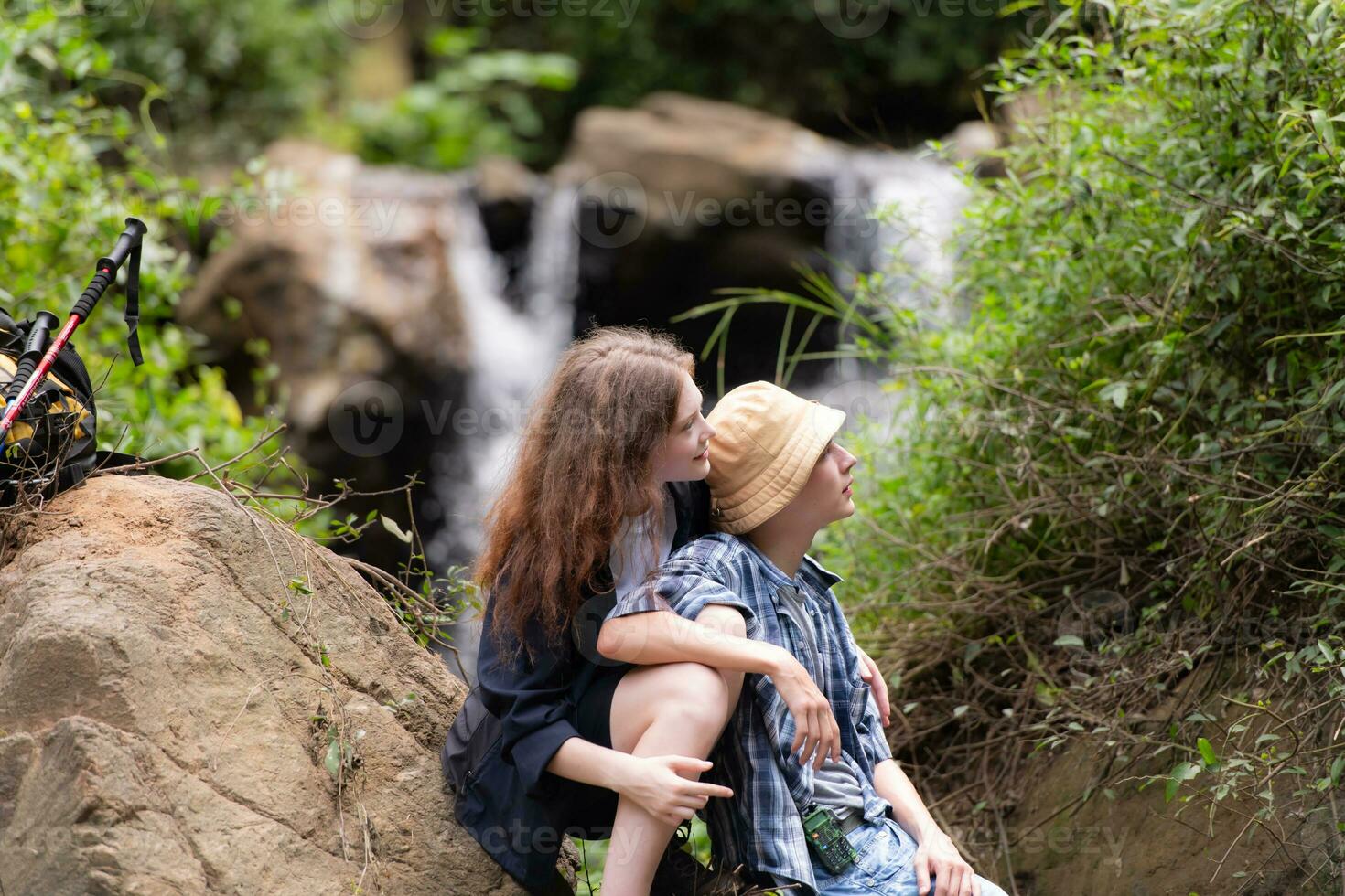 giovane coppia di escursionisti seduta su un' roccia e baci foto