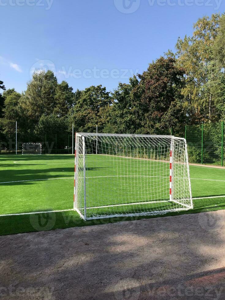 vuoto scuola calcio campo, cancelli nel il primo piano, verde prato, paesaggio foto