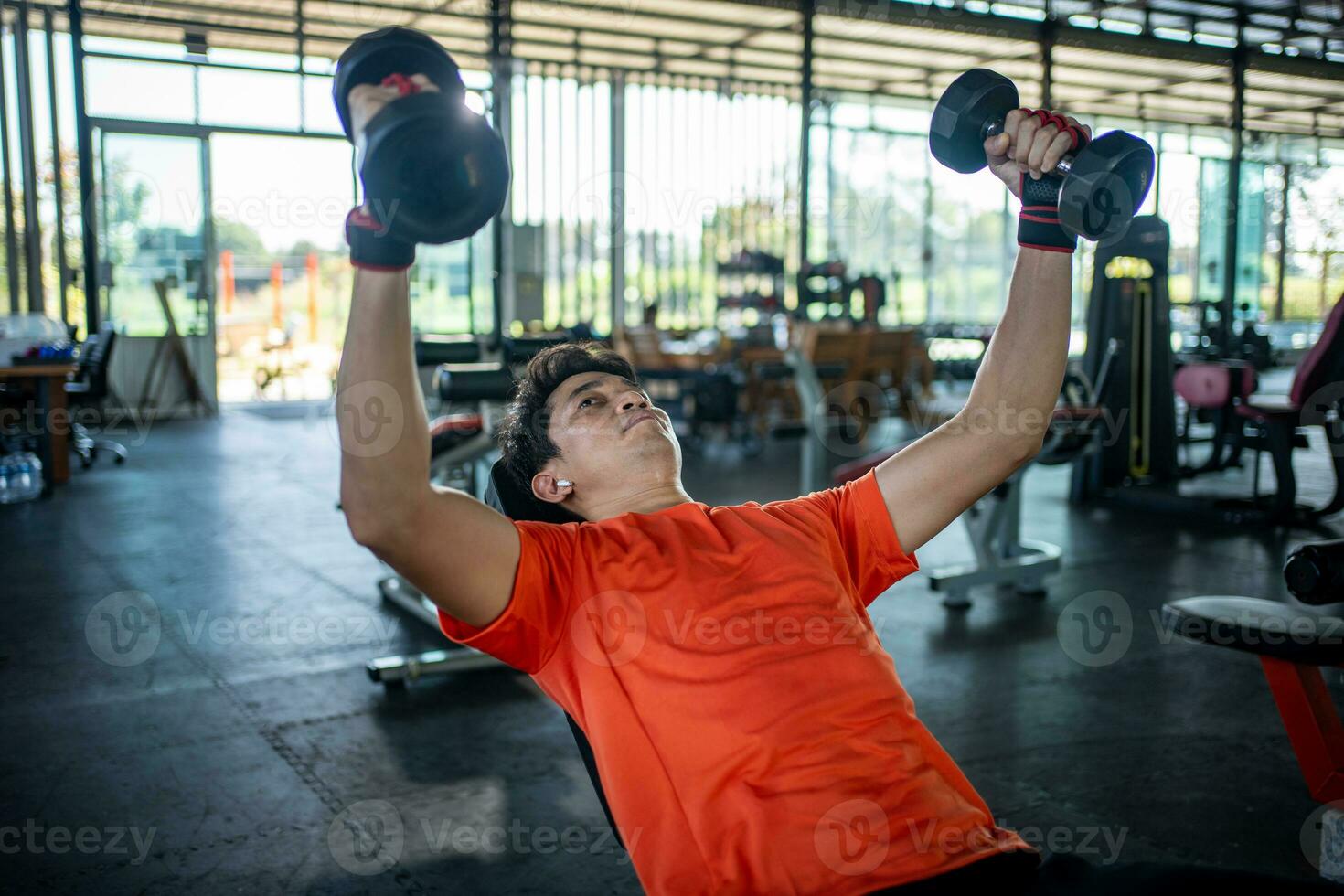 giovane uomo Lavorando su con manubri nel il Palestra foto