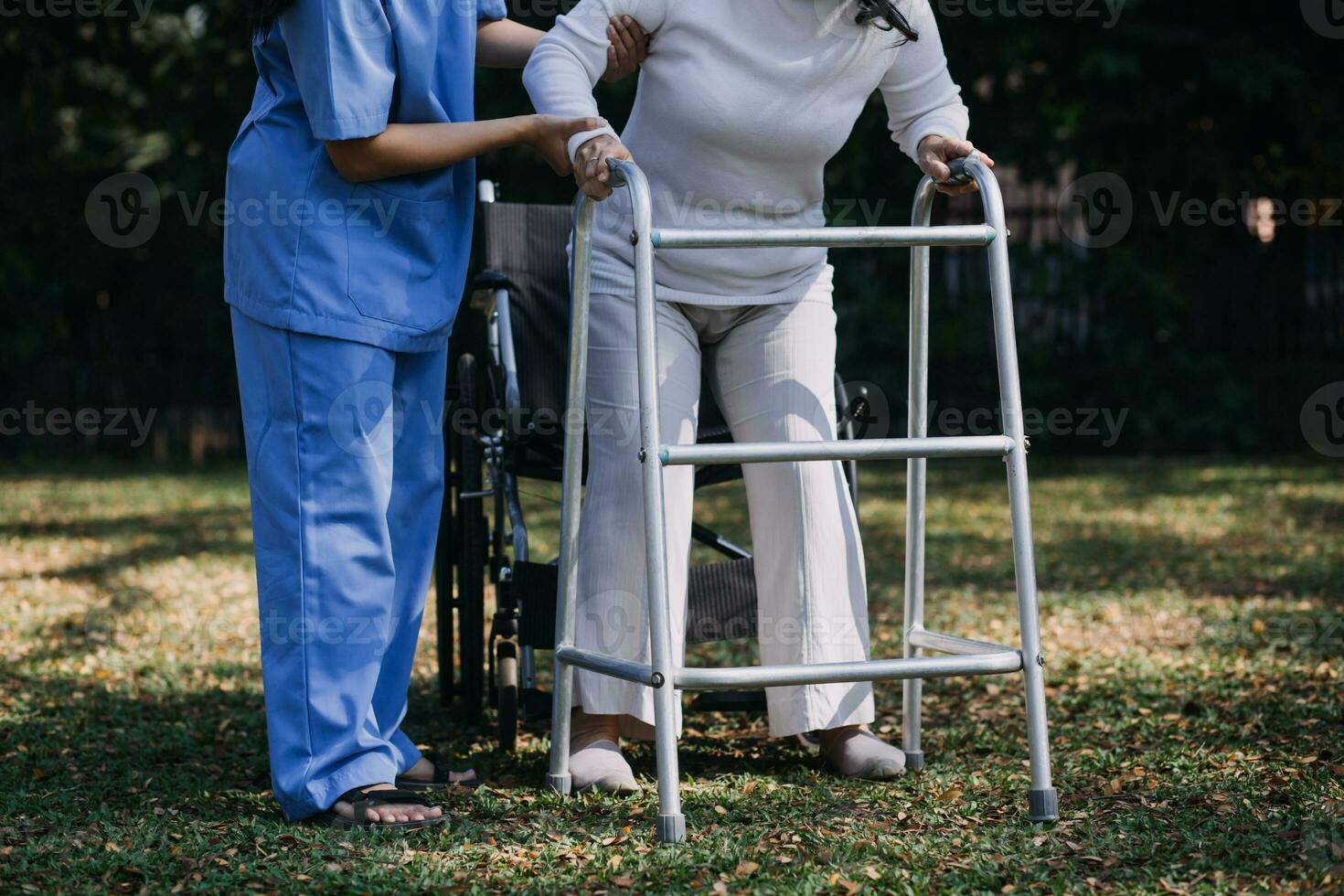 asiatico giovane donna infermiera a assistenza infermieristica casa prendere cura Disabilitato anziano uomo. badante medico servire fisico terapia per più vecchio anziano paziente per esercizio e pratica a piedi su camminatore o canna a Giardino dietro la casa. foto