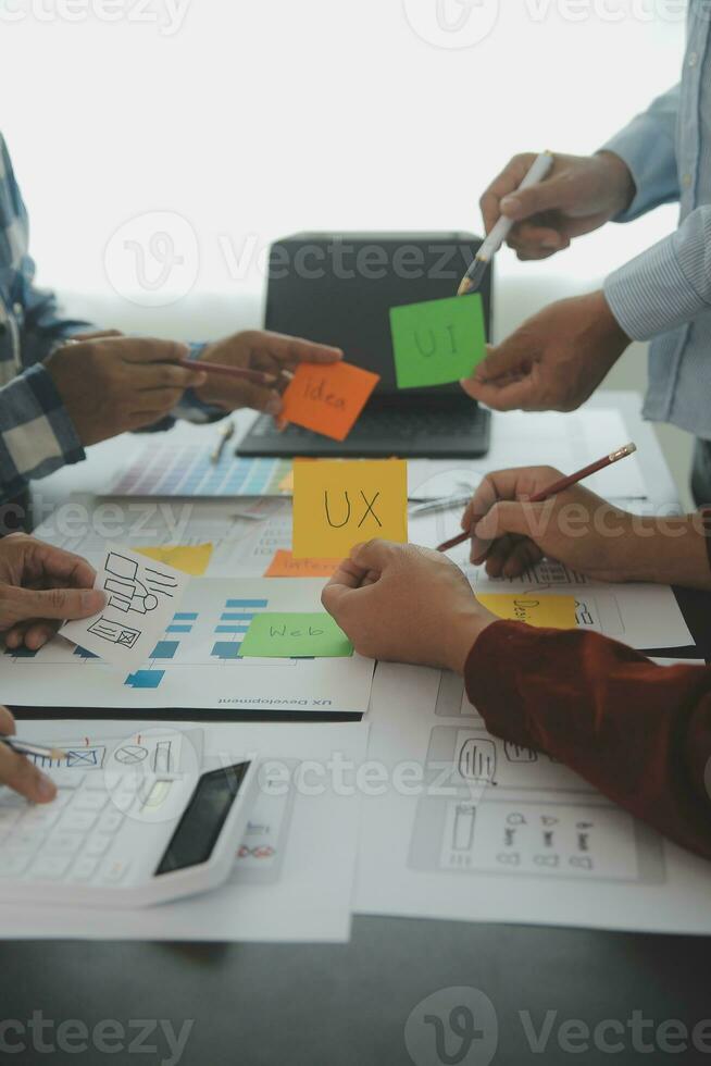 vicino su UX sviluppatore e ui progettista di brainstorming di mobile App interfaccia wireframe design su tavolo con cliente breve e colore codice a moderno ufficio.creativo digitale sviluppo agenzia foto