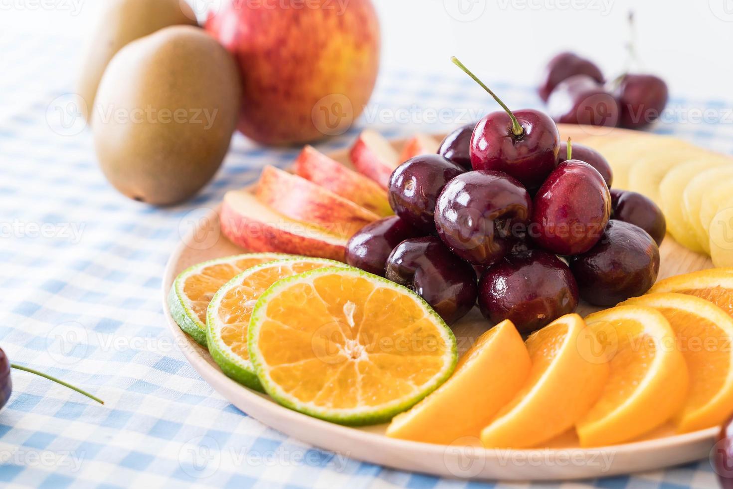 frutta mista a fette nel piatto di legno foto