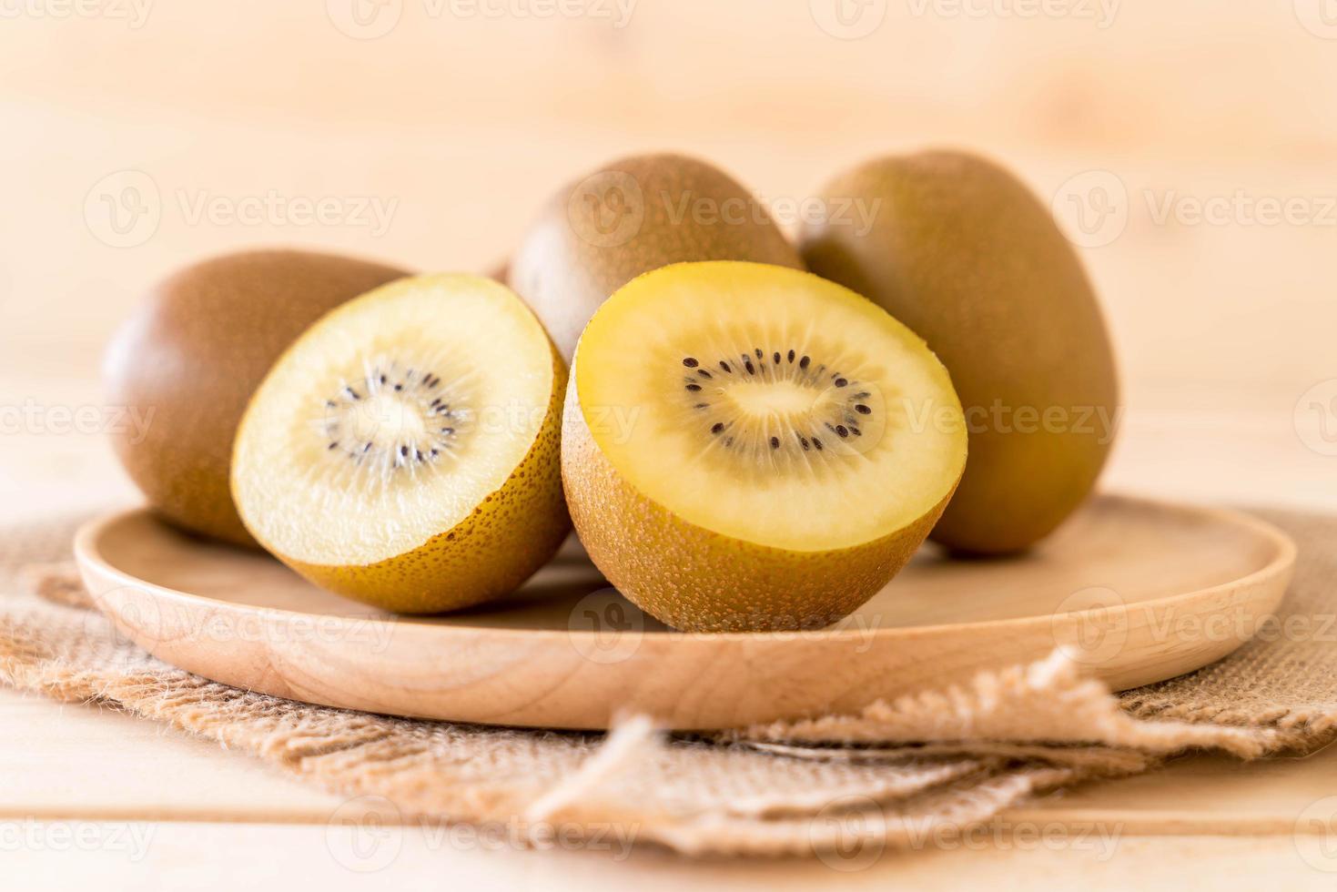 kiwi dorato fresco nel piatto di legno foto