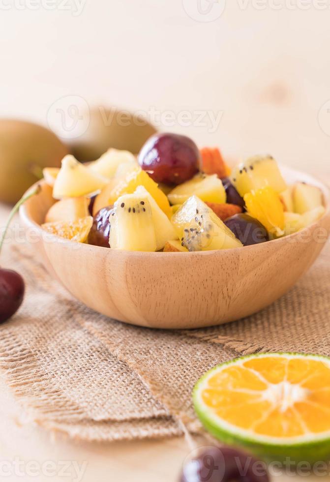 frutta mista affettata in ciotola di legno foto